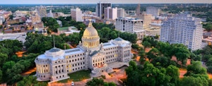 The state capitol building dominates the Jackson, Mississippi skyline at dusk.