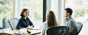 Smiling businesswoman in discussion with clients at office