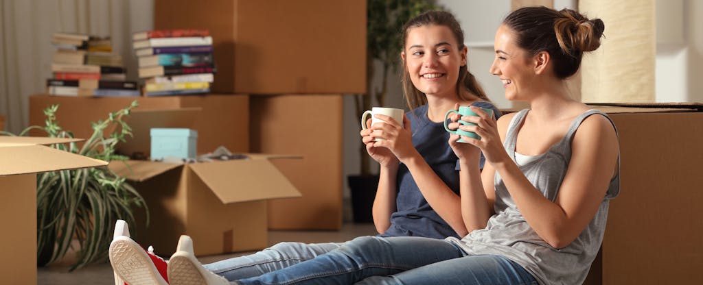 Two young roommates taking a coffee break on moving day