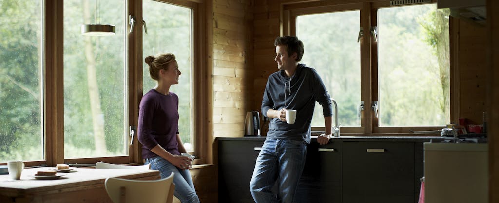 Couple having coffee in a cottage and chatting about their personal finances.