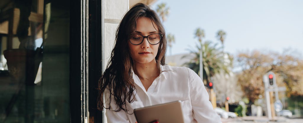 Woman sitting at a cafe working on digital tablet