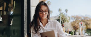 Woman sitting at a cafe working on digital tablet