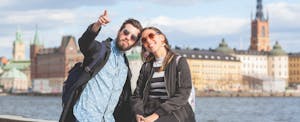 Happy young tourists in Sweden discussing how the country is almost cashless and how other countries could learn from Sweden.