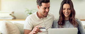 Couple looking at a laptop to find out what the best credit card offers are for new credit cards in 2017