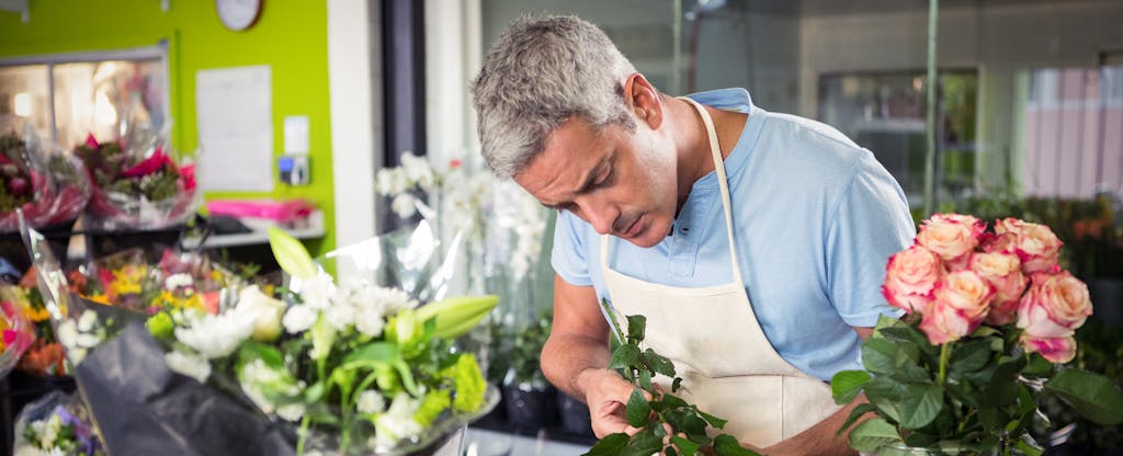 Man in his flower shop wondering if he should use a small business credit card
