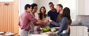 Group of young people toasting at a dinner party to celebrate a credit limit increase