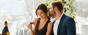 Young couple drinking wine in a fancy bar and maximizing the benefits of the Premier Rewards Gold Card from American Express