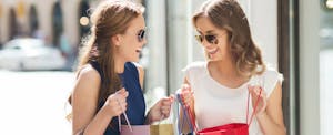 Two young women comparing shopping hauls