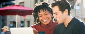 Young couple sitting outside and smiling