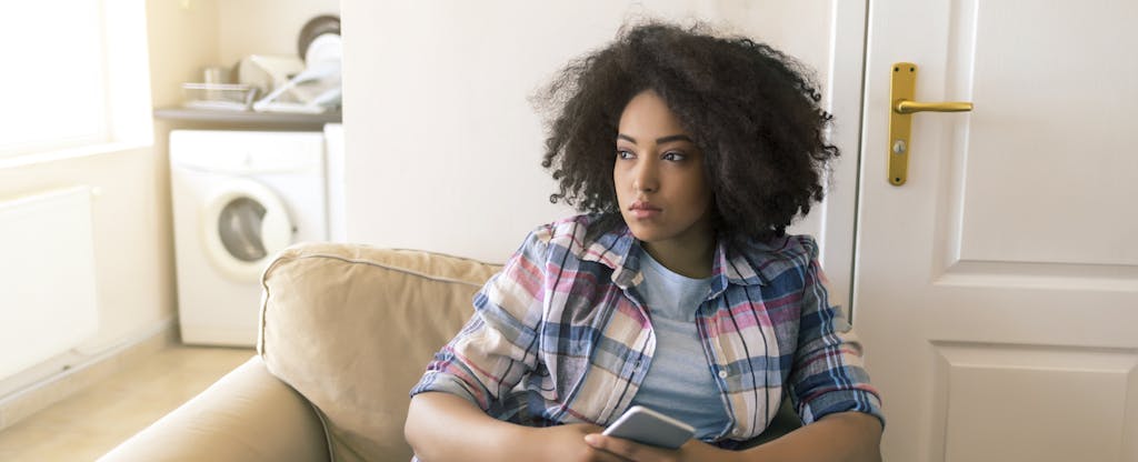Concerned-looking young woman wondering how long late payments stay on a credit report