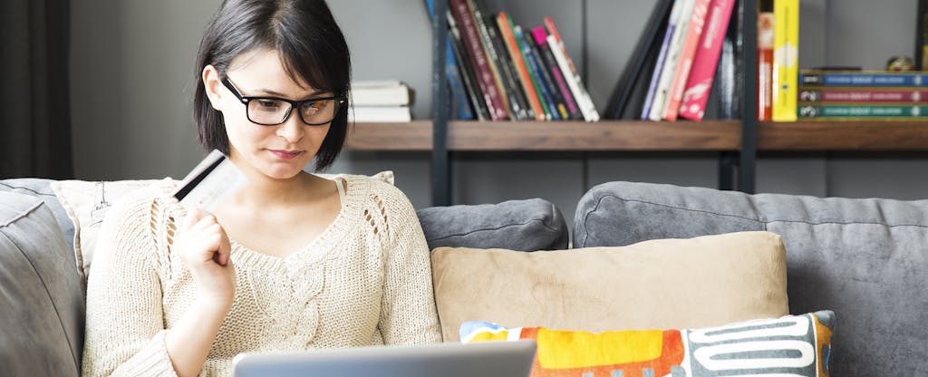 Woman on laptop explores how to lower credit card utilization rate