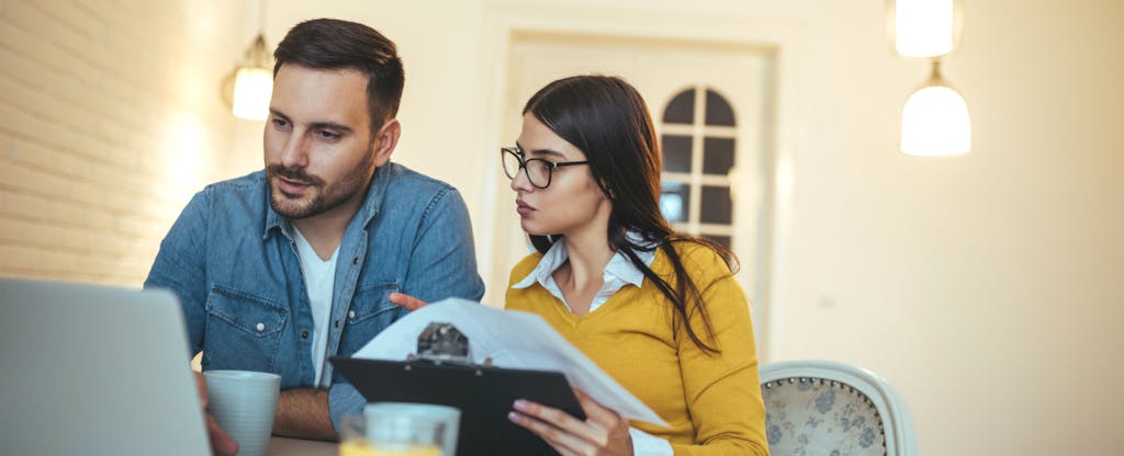 Couple analyzing bills realizing that household debt is on the rise in America