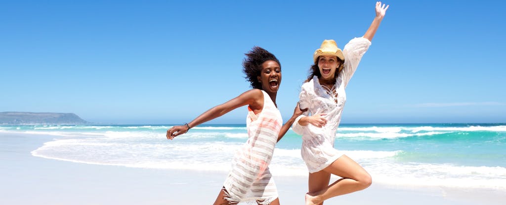 Two young woman on a beach vacation after learning about the Chase Sapphire Preferred benefits