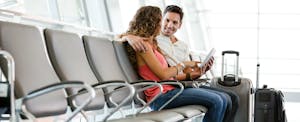 Couple at airport discussing the American Airlines AAdvantage program card.