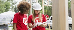 Two young women volunteers helping a charity build houses. Their charitable donations could net them a tax deduction.