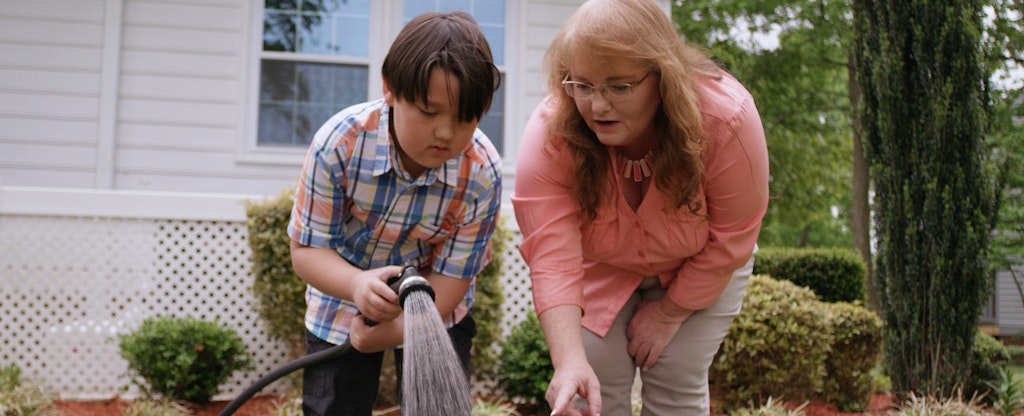 Donna helps her grandson tend the garden