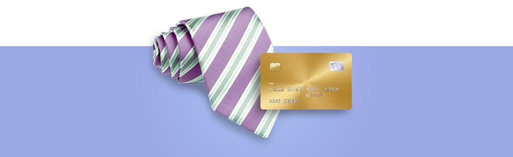 Rolled up tie pictured next to a business credit card for Credit Karma's Guide to Business Credit Cards.