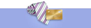Rolled up tie pictured next to a business credit card for Credit Karma's Guide to Business Credit Cards.