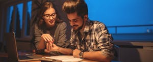 A young couple file their taxes with a free tax filing platform like TurboTax or Credit Karma Tax after reviewing the best free tax filing options.