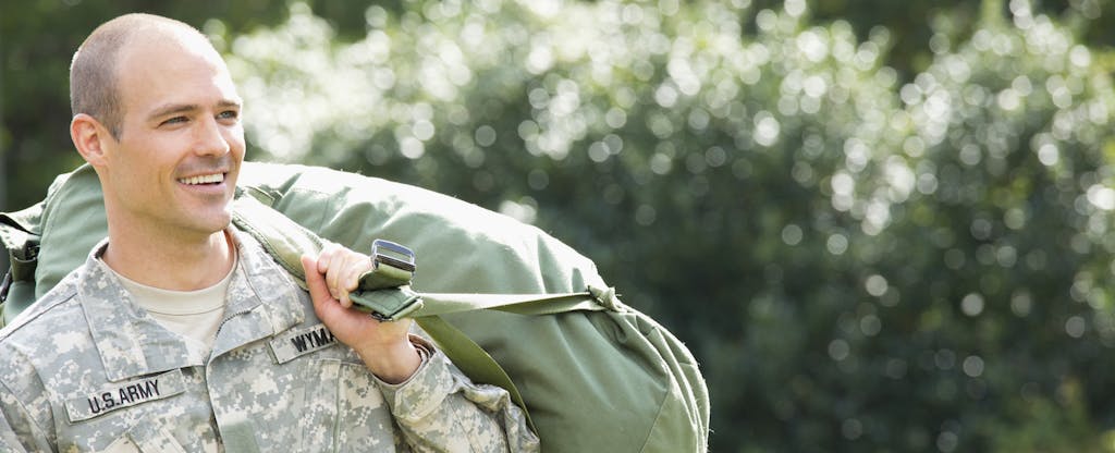 Soldier carrying duffel bag and wondering about best credit cards for active military duty personnel
