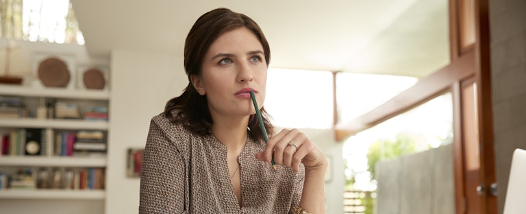 Pensive female working at desk in home office