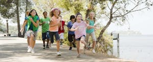 Children running and playing in summer camp. Their parents understand how FSAs work and the tax advantages they provide.