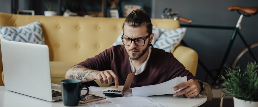 Young man in home interior going through household finances
