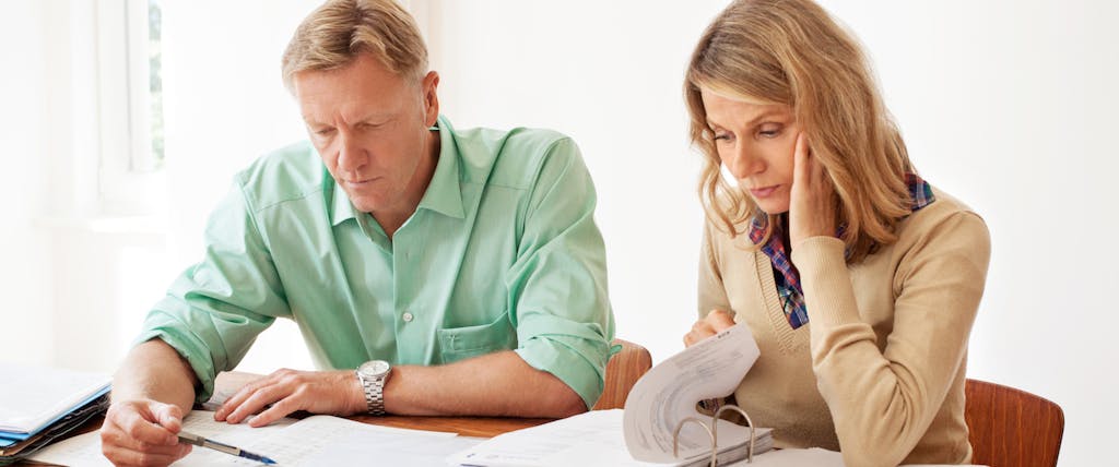 Mature woman and man calculating home finances at the table