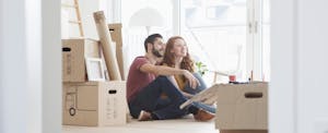 Happy young couple relaxing while unpacking after buying a home.