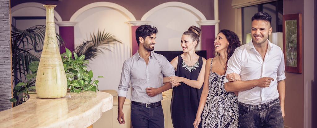 Two young couples leaving hotel lobby for night out