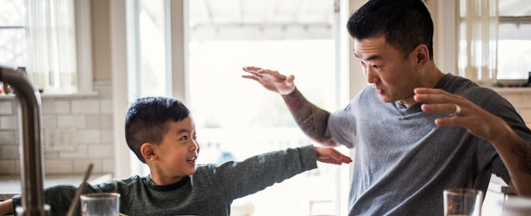 Father and son having breakfast in kitchen