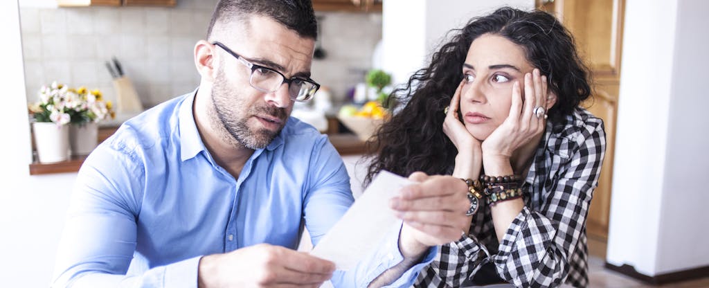 Worried couple looks at documents.