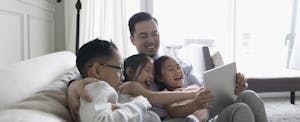 Happy father and children laughing together on a sofa