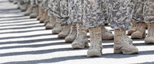 Ankle view of military service members in uniform, on a sunny day.