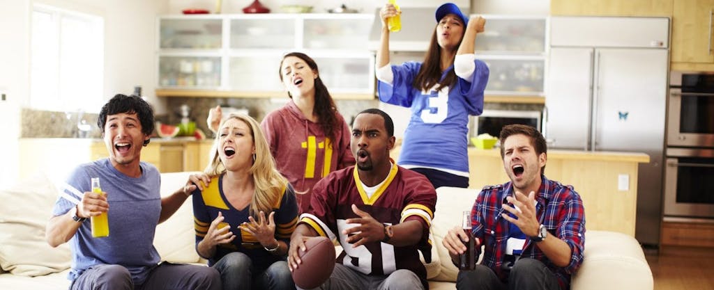 Friends watching a game together, not worried about tax on sports betting.