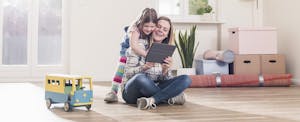 Mom and daughter playing in family room, mother confident that her family will benefit from tax cuts that take effect in 2018.