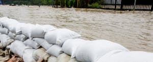A wall of sandbags holds back floodwaters.