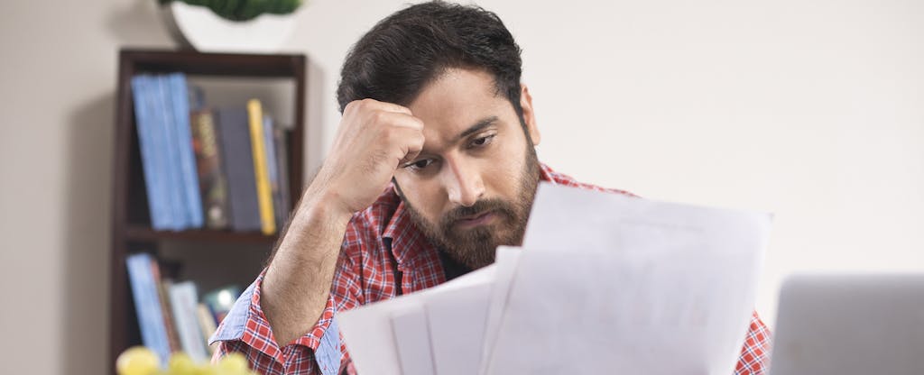 Worried man reading a document at home office