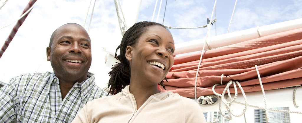 Happy couple sitting on a boat that they bought with a loan
