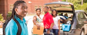 African-American family dropping their son off at college after discussing who will claim student tax credits.