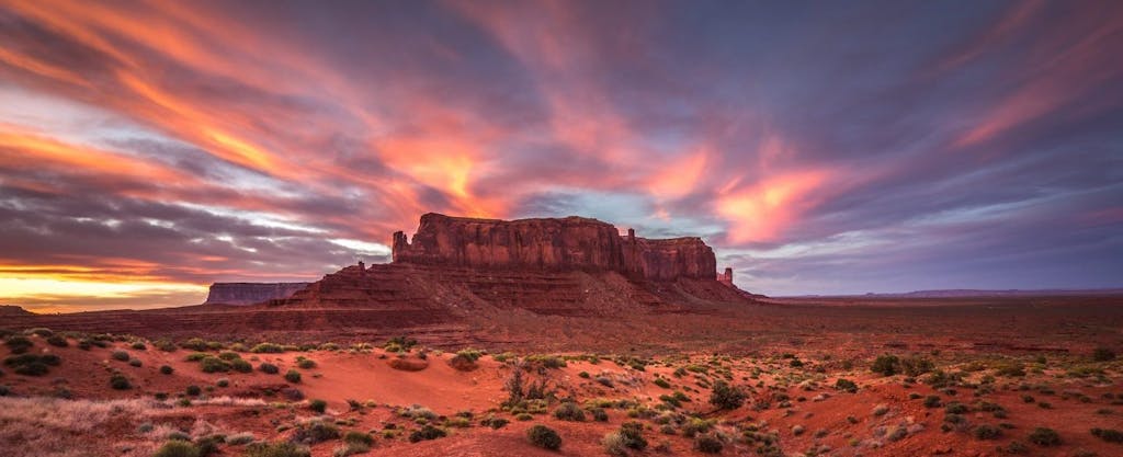 Sunset paints brilliant colors above Monument Valley in Arizona.