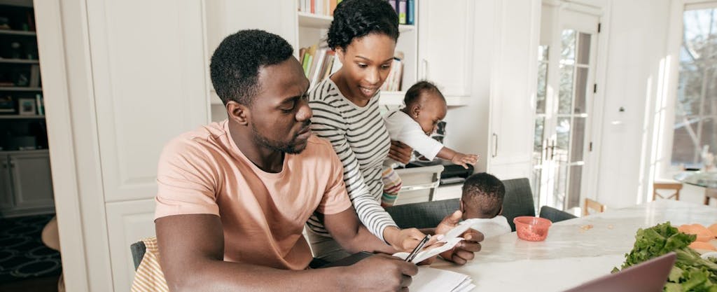 Young African American couple doing paper work and wondering if their state's SALT cap workaround will help them reduce their federal income taxes.
