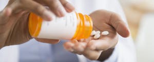 Pills pour out of a prescription bottle.