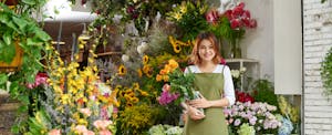 Smiling florist with bouquet of yellow tulips
