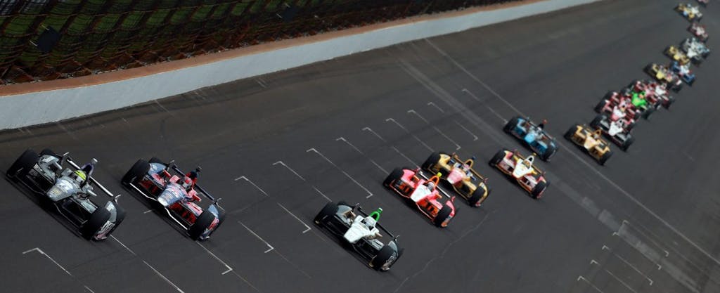 Cars race around the track in the Indianapolis 500.