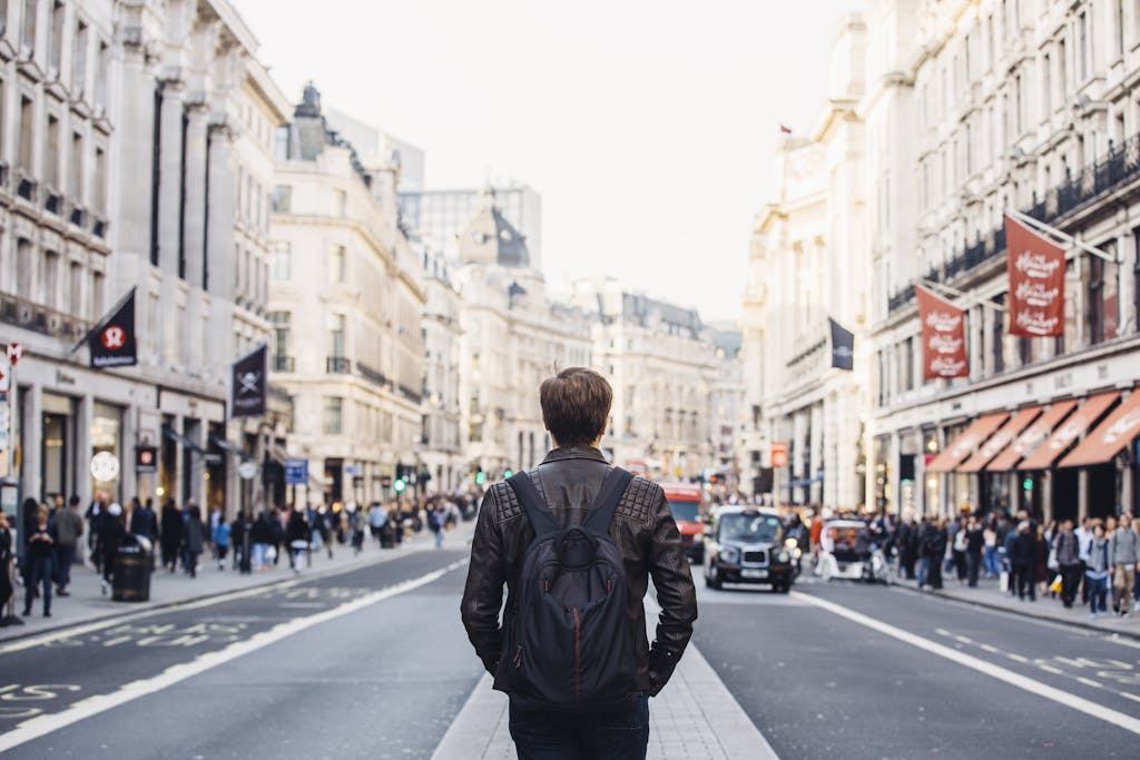 Tourist with backpack walking on Regent Street in London, UK