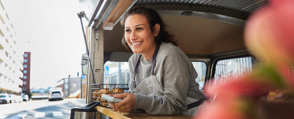 Smiling woman food truck owner in city