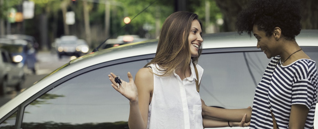 Young woman discussing the fair market value of her car with a male friend