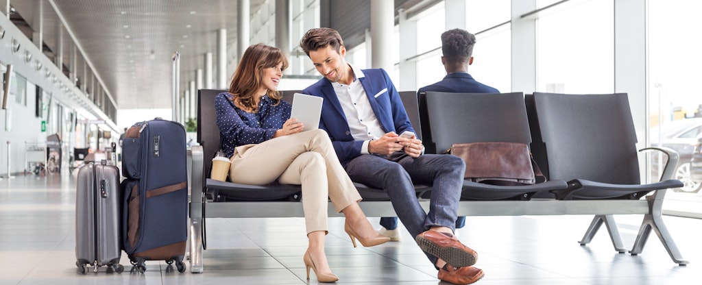 Young man and woman waiting for flight at the airport lounge.