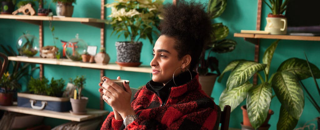 Woman holding a coffee and looking thoughtful